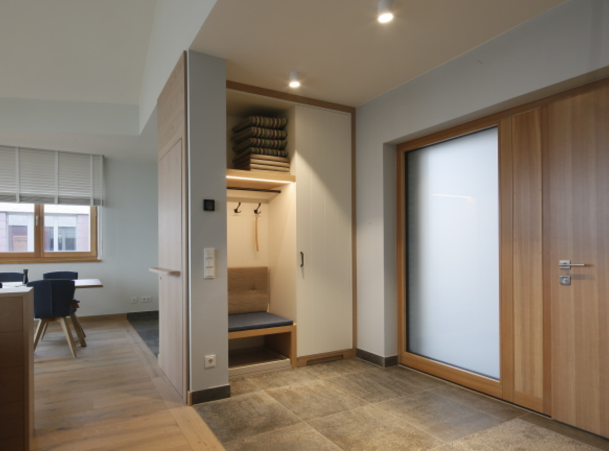 Eingangsbereich eines Hotelzimmers mit großem Holz und Glas Eingang.