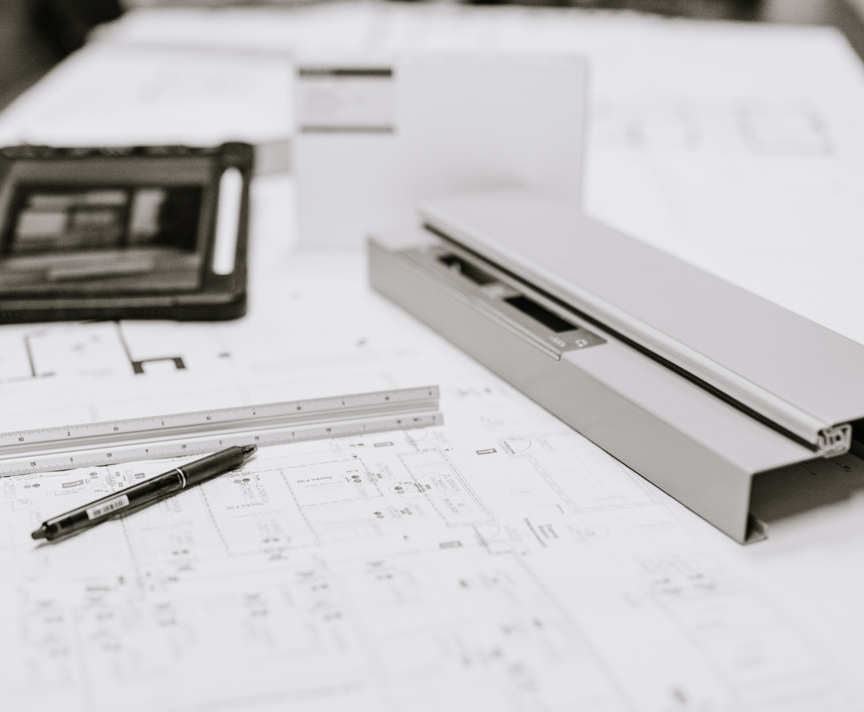 Ausgedruckte Pläne mit passenden Utensilien wie Lineal und Stift.