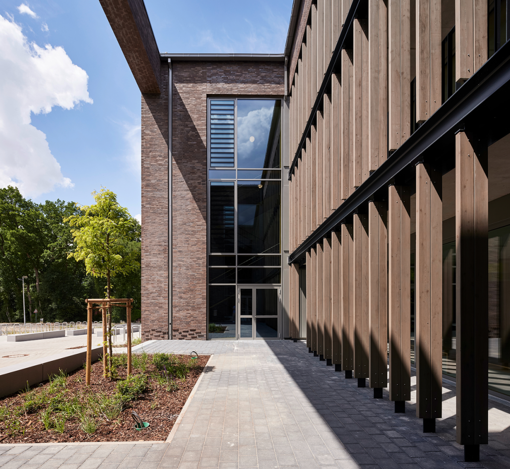 Außenbereich des Gymnasiums Lohne, die Front ist mit großen Holzträgern ausgestattet.