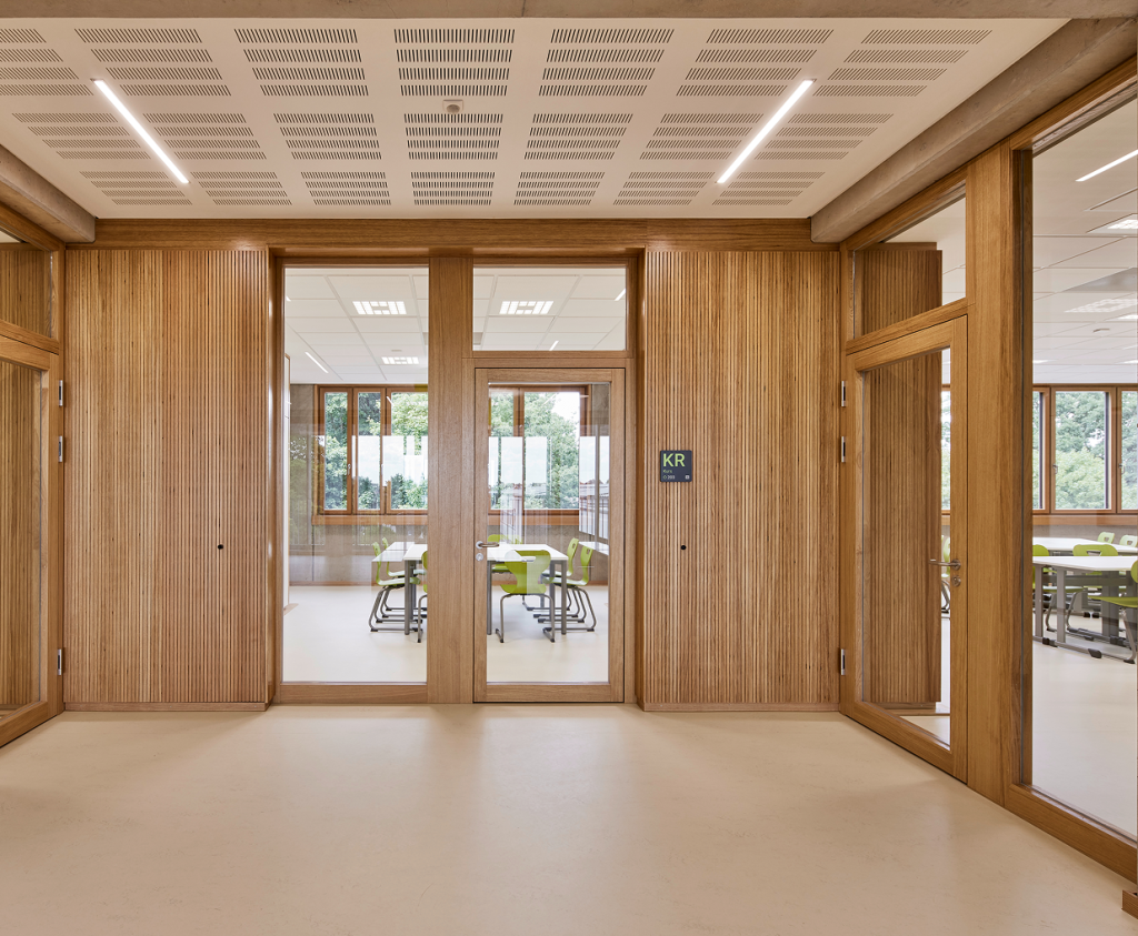 Große Doppeltür aus Holz und Glas mit Blick ins Klassenzimmer des Gymnasiums Lohne.