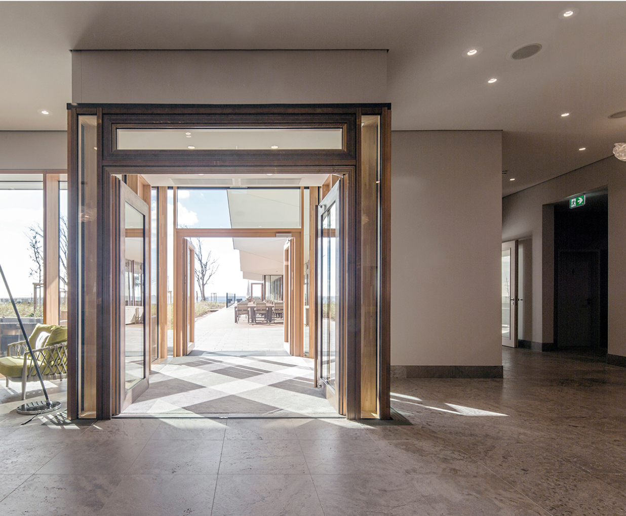 Eingangsbereich eines Hotels, im Mittelpunkt steht die Holzkonstruktion der Tür.