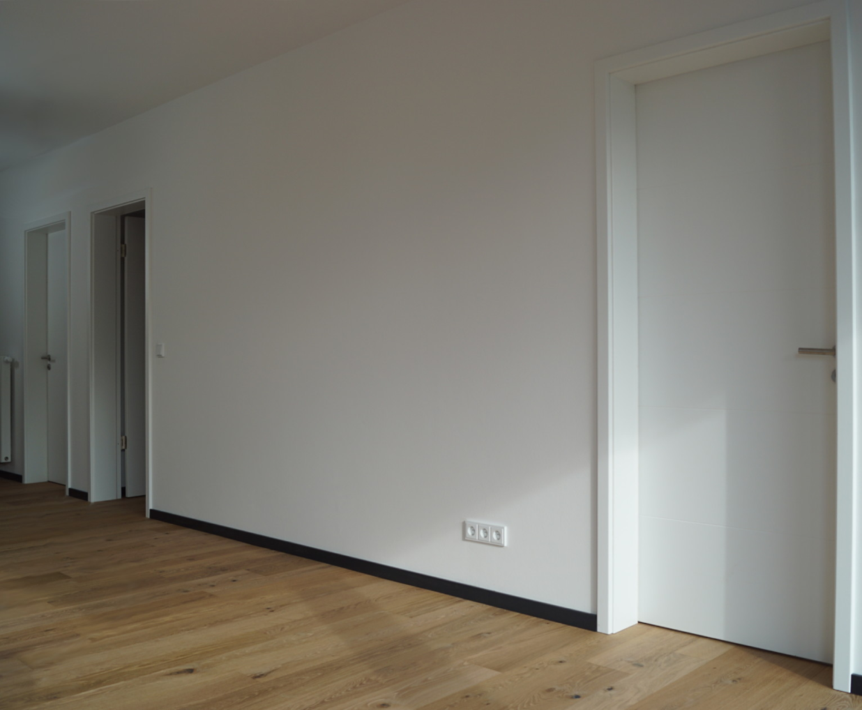 Ein Flur mit passenden Holzdielen und Holztüren.